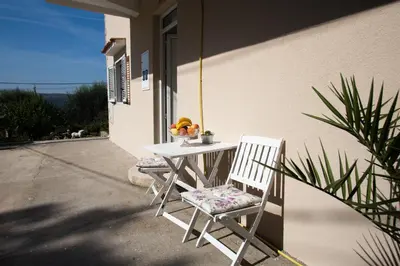 a table with two chairs and a bowl of fruit on it at Sunny Nest Apartments in Kotor