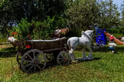 a statue of a horse pulling a cart in the grass at Sunny Nest Apartments in Kotor