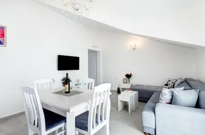a white living room with a table and a couch at Sunny Nest Apartments in Kotor