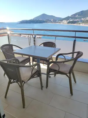 a table and chairs on a balcony with a view of the water at Apartments Stević - Monaco in Budva