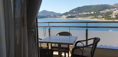 a table and chairs on a balcony with a view of the ocean at Apartments Stević - Monaco in Budva