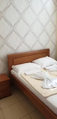 a bed with white sheets and white pillows on it at Apartments Stević - Monaco in Budva