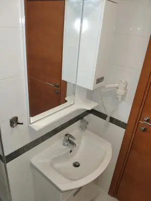 a bathroom with a white sink and a mirror at Apartments Stević - Monaco in Budva