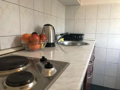 a kitchen counter with a bowl of apples and a sink at Villa Merci Budva in Budva