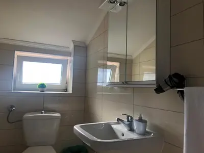 a bathroom with a sink and a toilet and a mirror at Villa Merci Budva in Budva