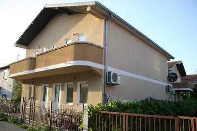 a house with a fence in front of it at Apartments EMERALD in Ulcinj