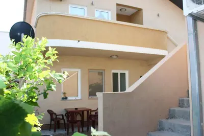 a staircase leading up to a house with a table and chairs at Apartments EMERALD in Ulcinj