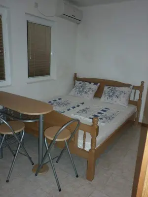 a bedroom with a bed and a table and chairs at Apartments EMERALD in Ulcinj