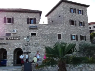 a group of people standing outside of a brick building at Apartments EMERALD in Ulcinj