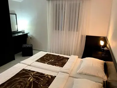a bedroom with a large bed and a television at Apartmani Dragović in Sveti Stefan