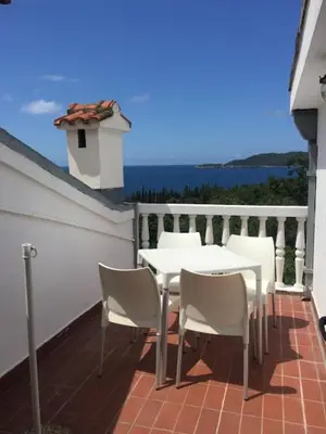 a white table and chairs on a balcony at Apartmani Dragović in Sveti Stefan