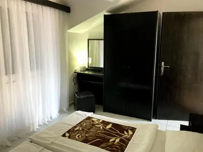a bedroom with a black cabinet and a mirror at Apartmani Dragović in Sveti Stefan