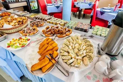 a table with plates of food on top at Hotel Lion in Ulcinj