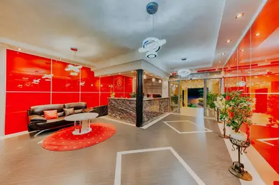a living room with red walls and a couch and a table at Hotel Lion in Ulcinj