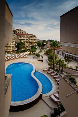 a view of a swimming pool with lounge chairs at Charming apartment near beach in Sveti Stefan