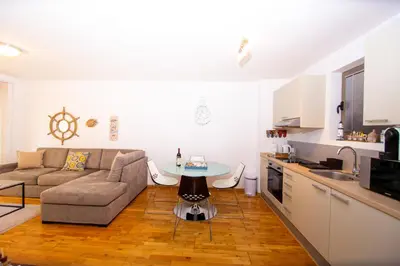 a living room with a couch and a table in a kitchen at Charming apartment near beach in Sveti Stefan