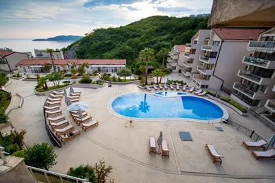 an overhead view of a swimming pool with lounge chairs at Charming apartment near beach in Sveti Stefan