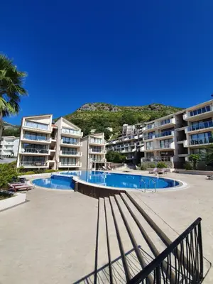 a swimming pool in front of some apartment buildings at Charming apartment near beach in Sveti Stefan