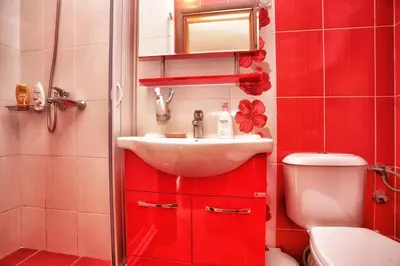 a red bathroom with a sink and a toilet at Apartments Simun in Kotor