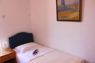a bedroom with a bed and a painting on the wall at Monten in Sveti Stefan