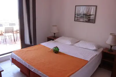 a bedroom with a bed with a plant on it at Monten in Sveti Stefan