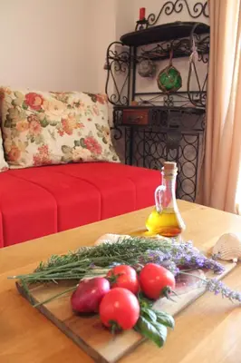 a tray of vegetables on a table with a bottle of oil at Monten in Sveti Stefan
