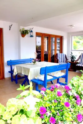 a blue table and chairs in a room with flowers at Monten in Sveti Stefan