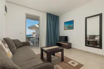a living room with a couch and a table and a television at Apartments Jovan in Sveti Stefan