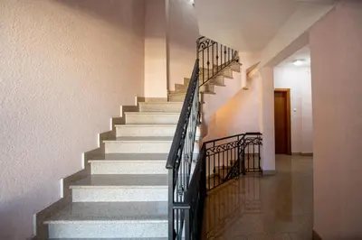 a staircase in a building with a metal railing at SunSea Apartments in Budva