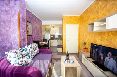 a living room with a purple couch and a tv at SunSea Apartments in Budva