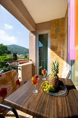 a table with a pineapple and two glasses of wine at SunSea Apartments in Budva