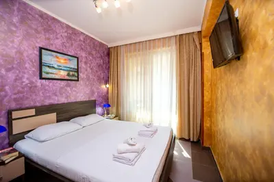 a bedroom with a large bed with towels on it at SunSea Apartments in Budva