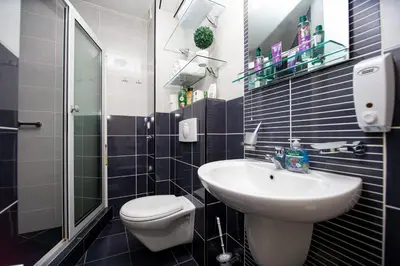 a small bathroom with a sink and a toilet at SunSea Apartments in Budva