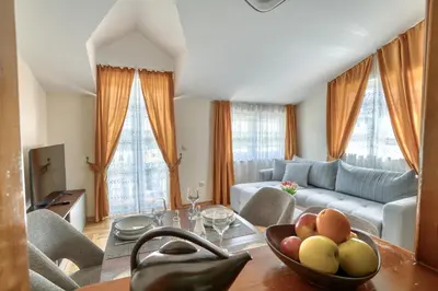 a living room with a couch and a table with a bowl of fruit at Apartments Elena in Budva