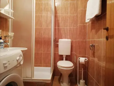 a small bathroom with a toilet and a shower at Apartment Oleander of Budva in Budva