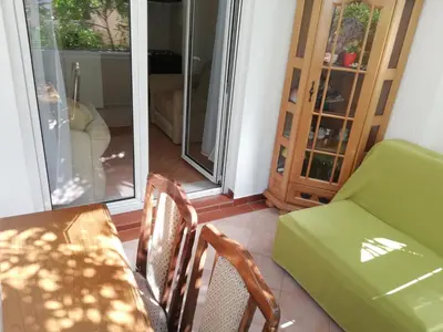 a dining room with a table and chairs and a couch at Apartment Oleander of Budva in Budva