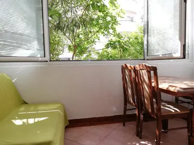 a room with a table and a chair and a window at Apartment Oleander of Budva in Budva