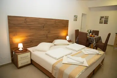 a bedroom with a bed with a large wooden headboard at Villa Andjelina in Budva