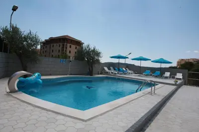 a swimming pool with a slide and umbrellas at Villa Andjelina in Budva