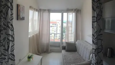 a living room with a couch and a large window at Apartments in Bar city center in Bar