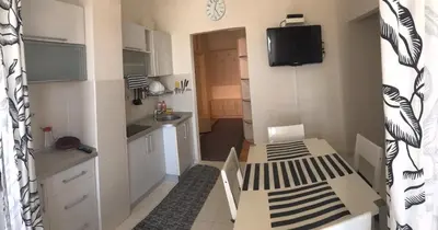 a small kitchen with white cabinets and a television at Apartments in Bar city center in Bar