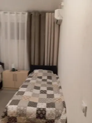 a bedroom with a bed with a checkered blanket at Apartments in Bar city center in Bar