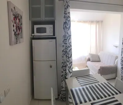 a small living room with a microwave on top of a refrigerator at Apartments in Bar city center in Bar