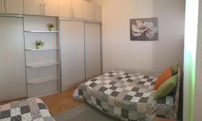 a bedroom with a bed and white cabinets at Apartments in Bar city center in Bar