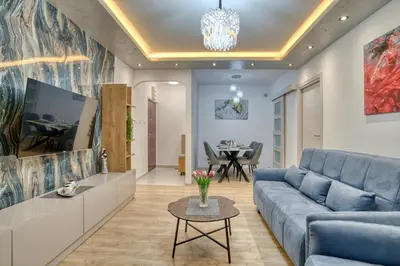 a living room with a blue couch and a table at COMFORT APARTMENT NEAR THE BEACH in Budva