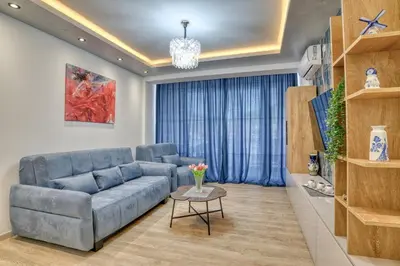 a living room with a blue couch and a table at COMFORT APARTMENT NEAR THE BEACH in Budva