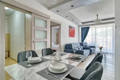 a dining room and living room with a table and chairs at COMFORT APARTMENT NEAR THE BEACH in Budva
