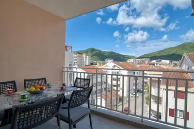 a balcony with a table and chairs and a view at COMFORT APARTMENT NEAR THE BEACH in Budva