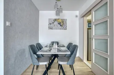 a dining room with a table and blue chairs at COMFORT APARTMENT NEAR THE BEACH in Budva