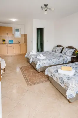 a room with three beds and a kitchen in it at Apartments Lejla in Dobra Voda